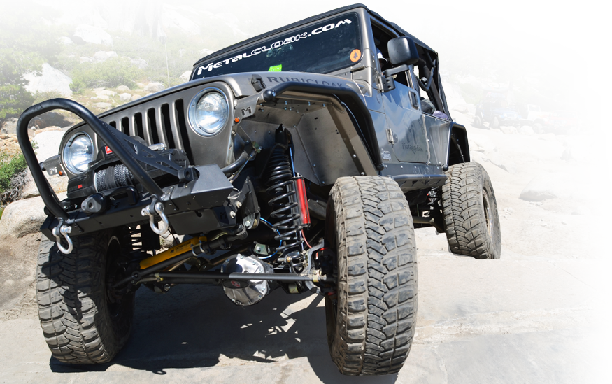 Gray Jeep TJ climbing rocks with MetalCloak 6Pak shocks installed